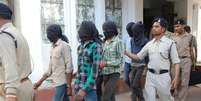 Acusados de estuprar uma turista suíça são escoltados até a corte de Datia  Foto: AFP