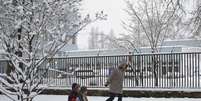 <p>Mãe usa trenó para puxar seus filhos em rua coberta pela neve em Budapeste, na Hungria, no começo da primavera no Hemisfério Norte</p>  Foto: Reuters