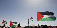 Ativistas seguram bandeiras da Palestina durante comemoração do "Yum al Ard"  Foto: Reuters