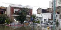 Homem observa a rua inundada na capital argentina  Foto: Reuters