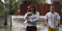 Mulher caminha pelas ruas alagadas de Buenos Aires  Foto: Reuters