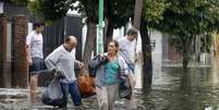 <p>Moradores carregam pertences em meio a alagamento na cidade argentina de La Plata</p>  Foto: Enrique Marcarian / Reuters