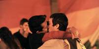 Do lado de fora da Câmara dos Deputados, uruguaios se beijam para comemorar a aprovação da lei   Foto: AFP