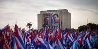 Cubanos participam de ato nas proximidades de prédio coberto com imagens de Chávez e do líder sindical Lazaro Peña  Foto: AP