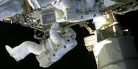 Dois astronautas da estação espacial internacional começaram uma caminhada no espaço neste sábado para consertar um vazamento de amônia em um sistema de refrigeração de um dos painéis solares da estação, que fornecem eletricidade para o posto orbital  Foto: AFP