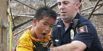 Menino é retirado dos escombros de escola por policial   Foto: Sue Ogrocki / AP