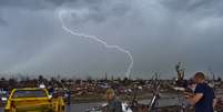 Sob mau tempo, moradores Moore, Oklahoma, limpam os destroços depois da passagem de um tornado, no dia 20  Foto: AFP