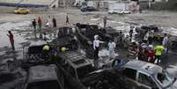 <p>Moradores observam carros destru&iacute;dos em explos&otilde;es em Bagd&aacute; na segunda-feira</p>  Foto: Reuters