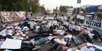<p>Ao ocupar todas as pistas, os manifestantes se deitaram no chão, como se representassem os corpos das vítimas da tragédia</p>  Foto: Luiz Roese / Especial para Terra