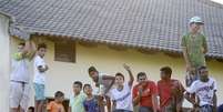 Sem permiss&atilde;o para ver a Sele&ccedil;&atilde;o de perto, populares se acumularam em casa e muros para ver o treino  Foto: Ricardo Matsukawa / Terra