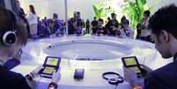 <p>Jovens jogam em videogames portáteis 3DS, da Nintendo, durante feira E3, nos Estados Unidos</p>  Foto: AP