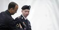 <p>O soldado americano Bradley Manning, acusado de traição por colaborar com o vazamento de documentos para o site WikiLeaks, é conduzido para o quarto dia de seu julgamento, em Fort Mead, Maryland</p>  Foto: AP