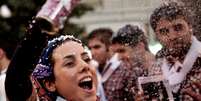 Mulher comemora com um spray a vitória de Hassan Rohani  Foto: AFP