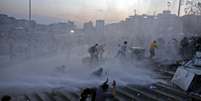 <p>Manifestantes correm após a polícia usar jatos de água no parque Gezi,  em Istambul</p>  Foto: Reuters