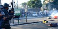 <p>Policiais usam gás e balas de borracha para impedir manifestantes de aproximar do Maracanã</p>  Foto: AFP