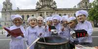 <p>Integrantes da ONG Enough Food for Everyone IF simulam preparar uma refeição temperada com impostos, em Belfast</p>  Foto: AP