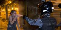 <p>Policial militar joga gás de pimenta no rosto de uma mulher durante o protesto no Rio de Janeiro</p>  Foto: AP