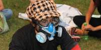 <p>Manifestante se previne contra o gás lacrimogêneo</p>  Foto: Diego Garcia / Terra