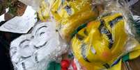 <p>Banca oferece uma máscara normal, na cor branca, e outra na versão amarela, além de bandeiras e nariz de palhaço</p>  Foto: Daniel Fernandes / Terra