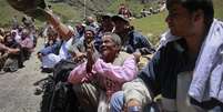 Em Badrinath, no Estado de Uttarakhand, sobrevivente das enchentes implora para que os soldados o levem com eles de helicóptero  Foto: Reuters