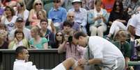 Tsongá é atendido com dores no joelho em Wimbledon  Foto: AP