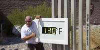Craig Blanchard posa ao lado de termômetro marcando 130°F (54,4°C) no Parque Nacional de Death Valley no sábado. A medida não era oficial  Foto: Reuters