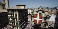<p>Enorme bandeira do País Basco foi estendida em prédio de Pamplona, causando o atraso das festividades</p>  Foto: EFE