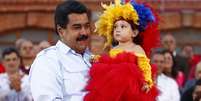 Nicolás Maduro segura criança durante cerimônia para comemorar o 59º aniversário de nascimento de Chávez, em Caracas  Foto: Reuters