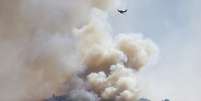 Treze helicópteros e seis tanques aéreos participam nas operações de combate ao incêndio  Foto: AP