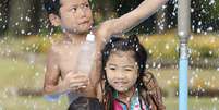 <p>Crian&ccedil;as brincam em uma fonte em Kumagaya, perto de T&oacute;quio, em um dia de calor de 40&deg;C</p>  Foto: AP
