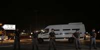 Policiais israelenses protegem veículo que leva prisioneiros palestinos durante a passagem para Gaza  Foto: AP