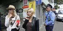 As ativistas Yana Zhdanova (centro) e Alexandra Shevchenko (esq.) em frente ao escrit&oacute;rio do Femen em Kiev, na ter&ccedil;a-feira, ap&oacute;s revista policial  Foto: Reuters