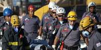 Bombeiros carregam em maca corpo da 10&ordf; v&iacute;tima encontrada morta sob os escombros  Foto: Bruno Santos / Terra