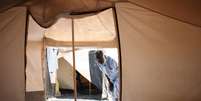 Mohammed Abdullah entra em sua tenda, que divide com sua família, em campo de refugiados na Jordânia  Foto: AP