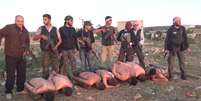 <p>Frame do vídeo em que sete soldados sírios são executados; Issa aparece na direita da imagem</p>  Foto: Reprodução