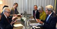 As comissões russa (esq.) e americana, lideradas pelos chanceleres Lavrov e Kerry (centro), na reunião em Genebra  Foto: AP