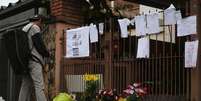 Cartazes e flores s&atilde;o deixados em frente &agrave; casa da fam&iacute;lia em homenagem &agrave;s adolescentes  Foto: Alex Falc&atilde;o / Futura Press