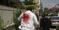Homem ferido deixa local do ataque no shopping Westgate Mall, no Quênia  Foto: AP