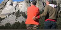 Casal que viajou da Carolina do Sul para ver o Monte Rushmore, localizado na Dakota do Sul, encontrou o parque nacional do monumento fechado em função do embate entre governo e oposição nos EUA  Foto: AFP
