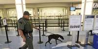 Policial vistoria terminal do aeroporto de Jacksonville com cão farejador  Foto: AP