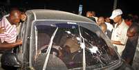 Pessoas cercam na noite de quinta-feira o carro em que o religioso foi baleado em Mombasa  Foto: AP