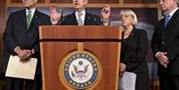 O senador democrata Harry Reid (centro) fala à imprensa sobre a aprovação do acordo no Senado  Foto: AP