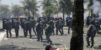 Manifestantes ficaram caídos no chão para desviar de ataques da Força Nacional, que faz a segurança do leilão do pré-sal  Foto: Reuters