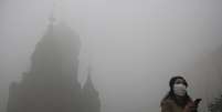 Mulher usa m&aacute;scara para se proteger da polui&ccedil;&atilde;o em Harbin  Foto: Reuters