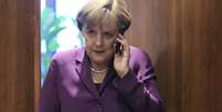 <p>Imagem de arquivo mostra Merkel usando o telefone antes de uma reuni&atilde;o da UE em Bruxelas</p>  Foto: Yves Herman / Reuters