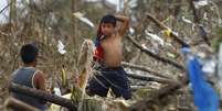 Moradores andam pelos destroços na cidade de Tacloban  Foto: AP
