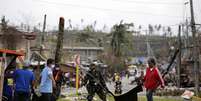 Soldados e policiais removem cadáveres a céu aberto na cidade de Tacloban  Foto: EFE