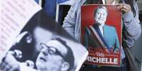 <p>Partidário da candidata à presidência do Chile Michelle Bachelet, da Nueva Mayoria, levanta cartaz próximo a imagem do ex-presidente socialista Salvador Allende durante comício na vidade de Valparaíso</p>  Foto: Eliseo Fernández / Reuters