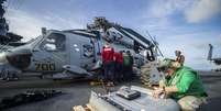 Equipe remove equipamentos do porta-aviões para dar lugar a suprimentos e pessoal enviados às Filipinas  Foto: AP