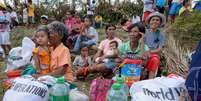 Filipinos recebem comida e material de limpeza na cidade de Tabogon  Foto: EFE